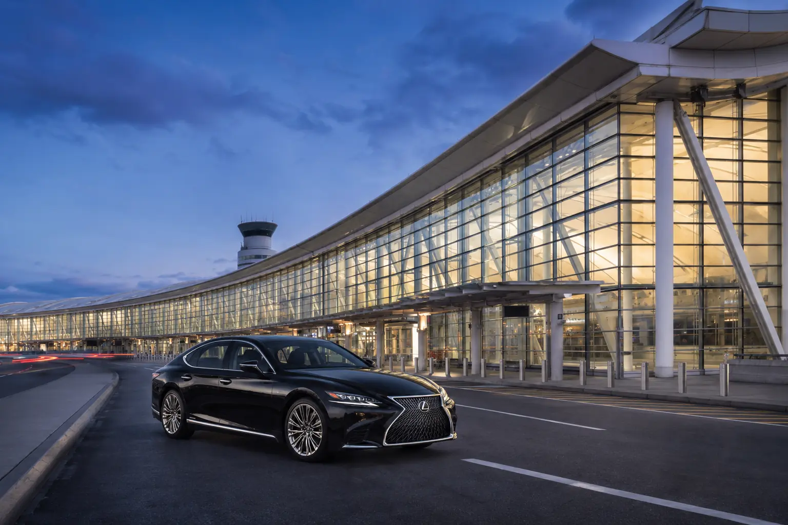 Chauffeured vehicle waiting outside a modern airport terminal