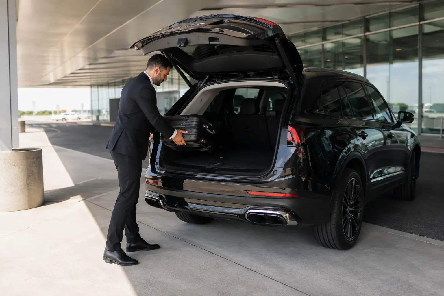 Chauffeur loading suitcases into a vehicle trunk before an airport transfer in Toronto